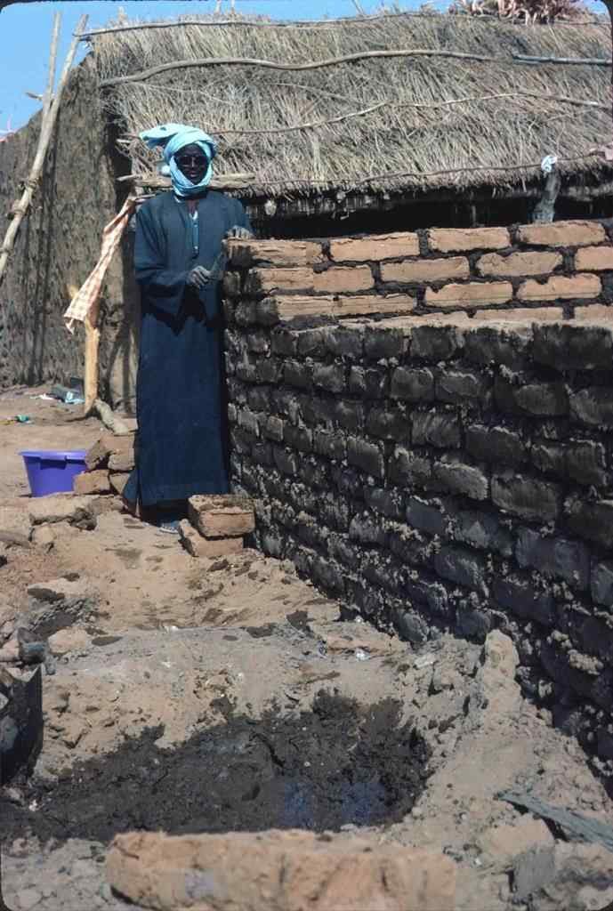 Sadyo Konate repairs a wall